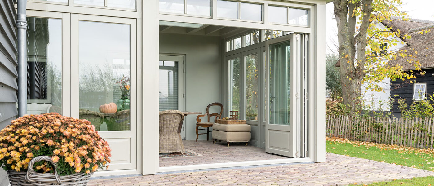 Een landelijke houten serre met harmonicadeuren op maat