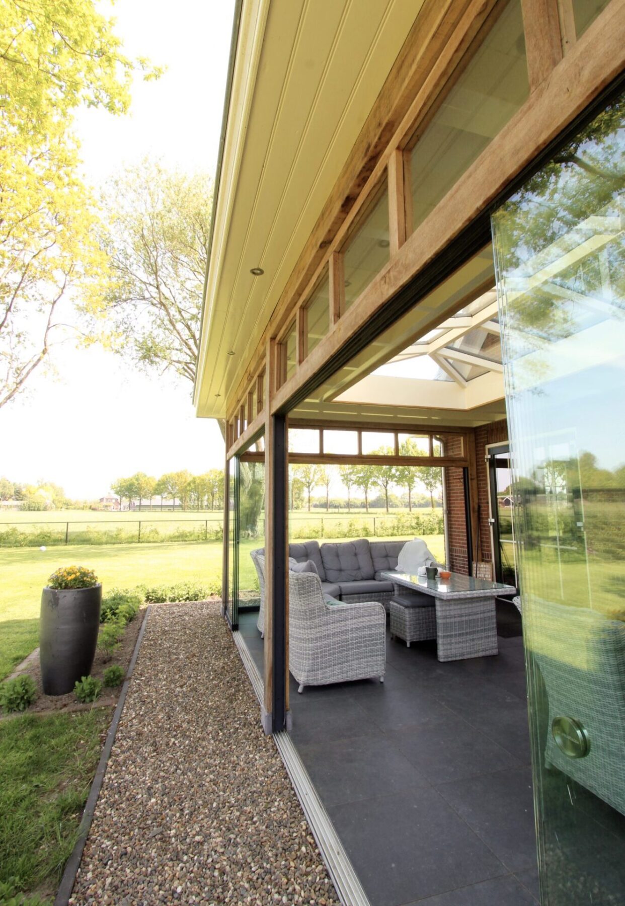 Landelijke tuinkamer met glazen schuifwanden en lichtstraat