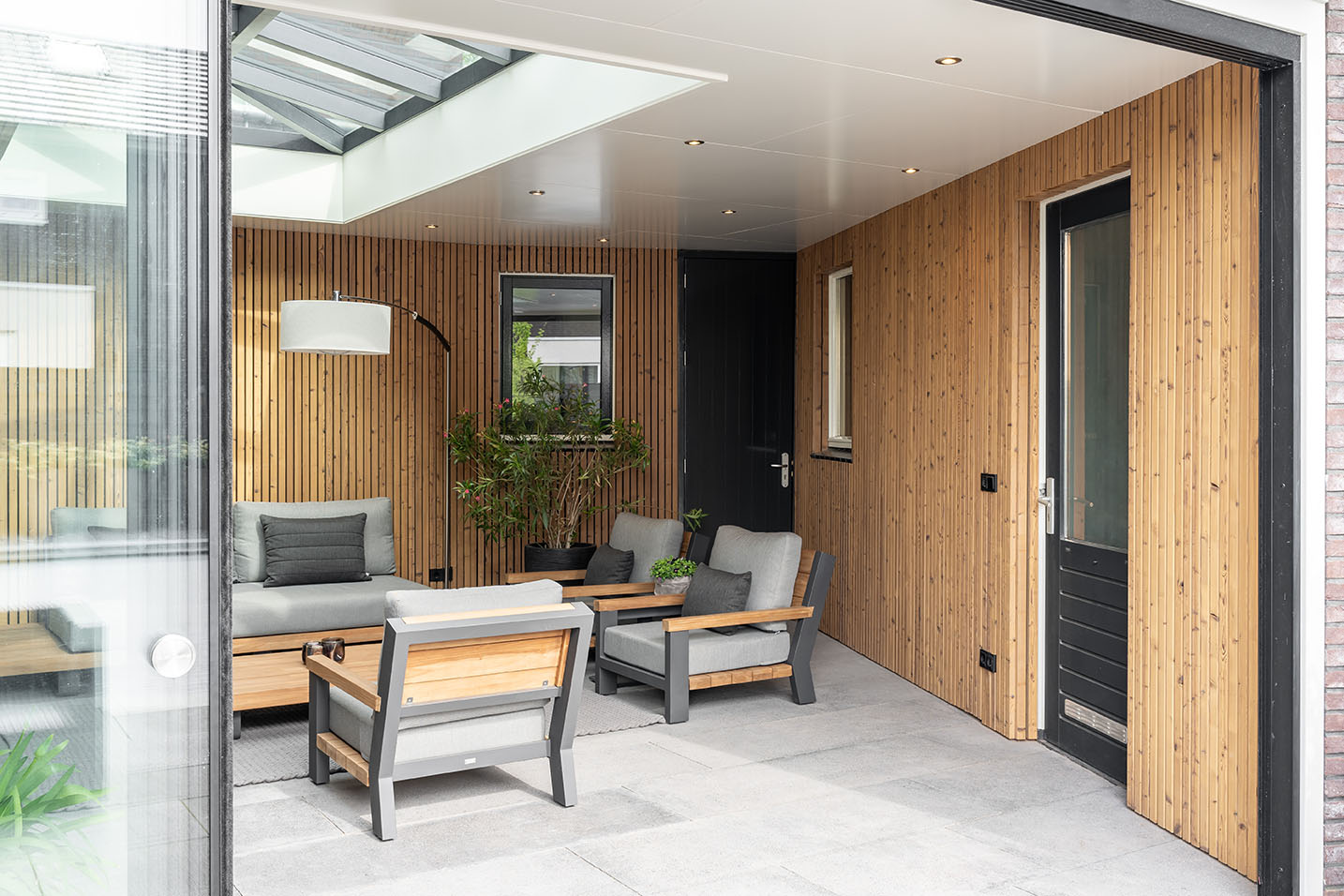 Moderne tuinkamer met industriële glazen schuifwanden en lichtstraat