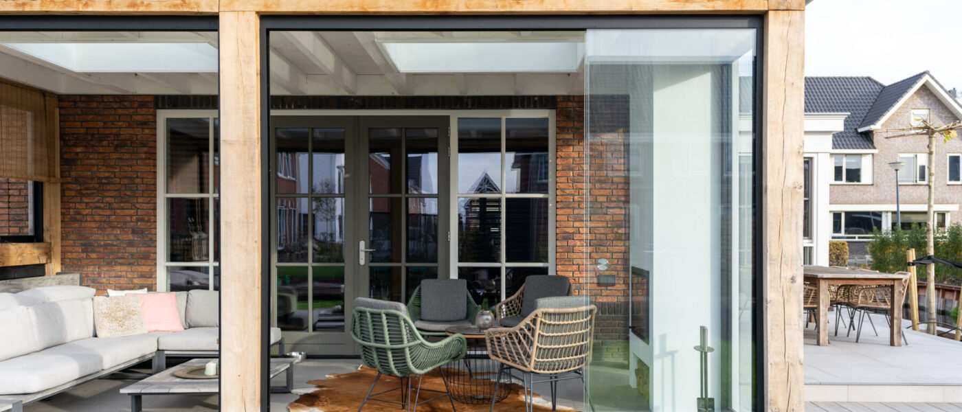 Een landelijke tuinkamer met glazen schuifwanden